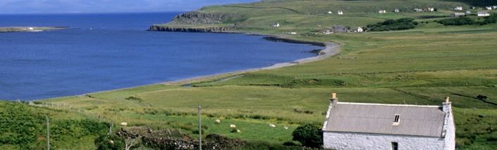 A quaint scottish cottage standing on a clifftop