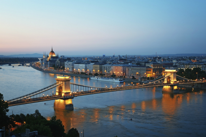 A view of the majestic Budapest skyline by night, the river and the bridge