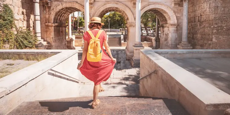 A female tourist walks towards the three arches at Hadrian's Gate in the old town of Antalya. 