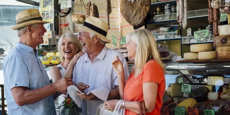 Group of travellers enjoying themselves while looking around an Italian delicatessen on a day trip to Via San Cesareo. 