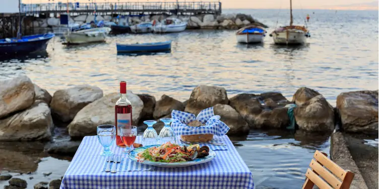 an image of a dinner table for two by the sea harbour in Sorrento, Italy