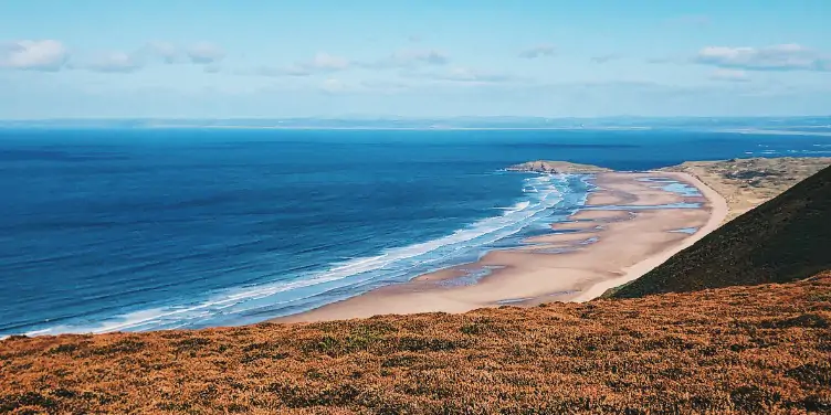 an image of Rhossili beach from the clifftop