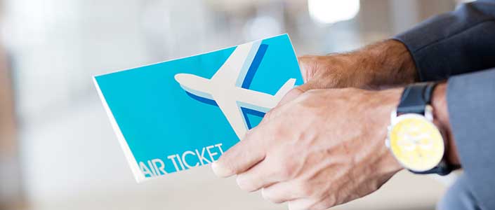 A man's hands holding an air ticket booklet