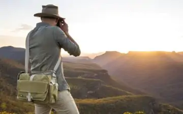 Man photographs sunset on a mountain range in Australia