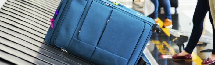 Navy blue personal baggage on a conveyor belt