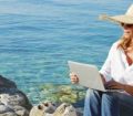 Woman on beach with laptop