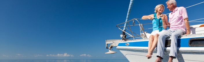 Happy Senior Couple on the Bow of a Sail Boat