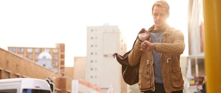 Man looking at his watch in busy street