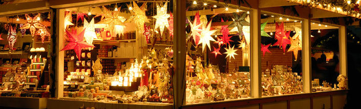 A stall at a christmas market, lit up with star shaped lights