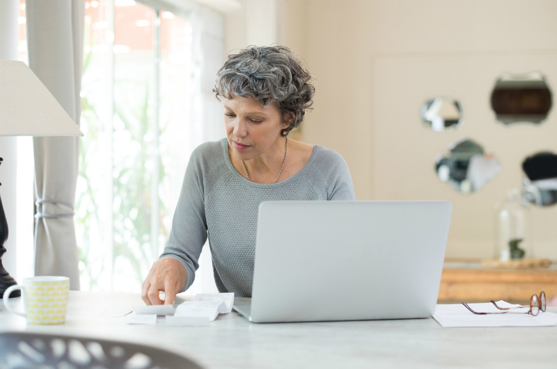 Mature woman checking bills