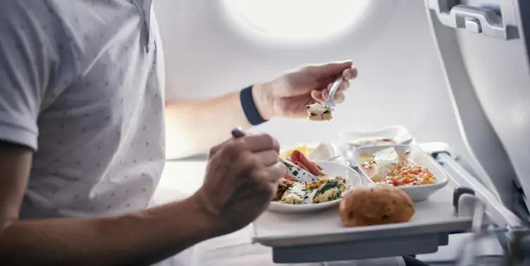 Mature male eating his meal on the plane. 