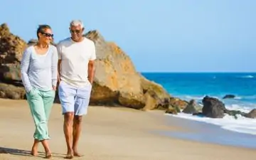 middle aged couple walking on the beach together