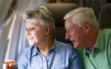 older couple looking out of window of airplane