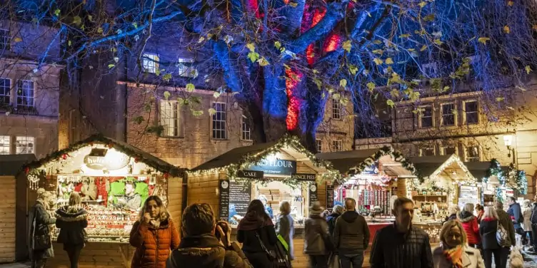 People strolling through the Bath Christmas market in the evening