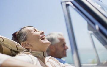 Silver Migration: Happy Mature Travellers Driving In Car