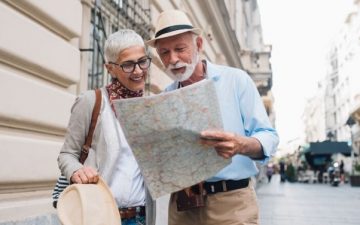 senior couple looking at map in city