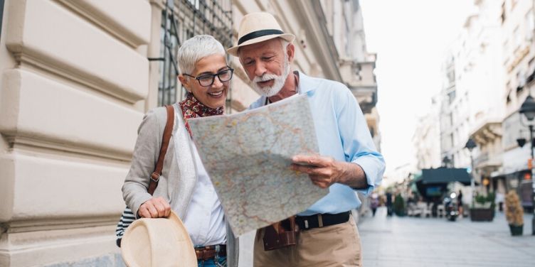 senior couple looking at map in city