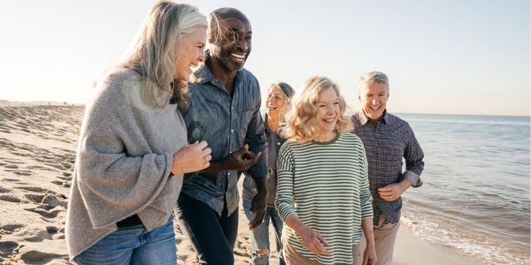 group of seniors laughing on beach