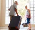 Senior couple leaving for holiday with luggage