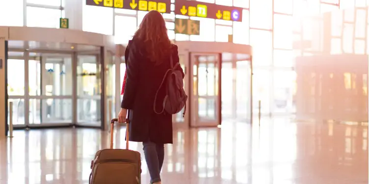 an image of a woman leaving the arrivals section of an airport