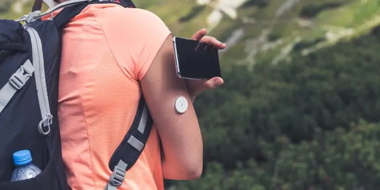 Person checking glucose levels with flash glucose monitor