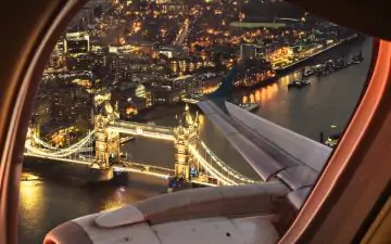 an image of Tower Bridge in London at night from the view of a plane window