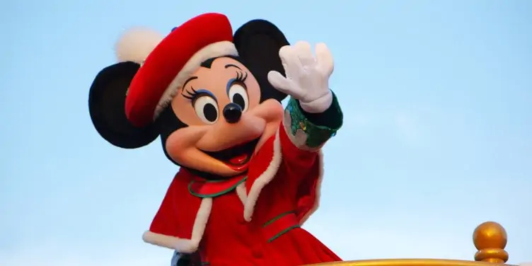 Minnie Mouse waving at crowds during a parade