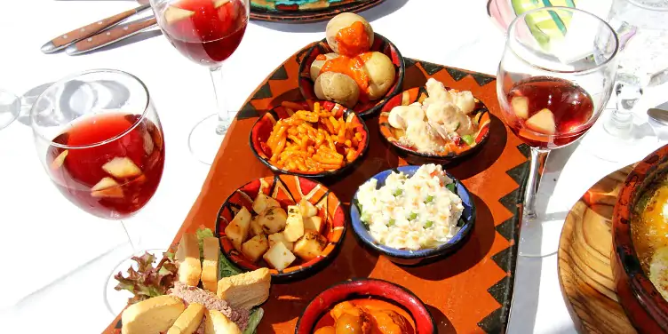 Spanish salad spread and wine on a table