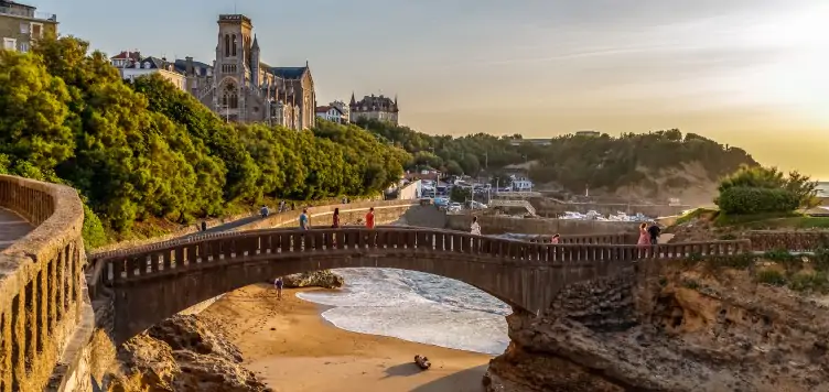 Scenic view of the famous stone bridge Rocher Du Basta Cityscape in Biarritz with peaceful sand beaches in the distance. 