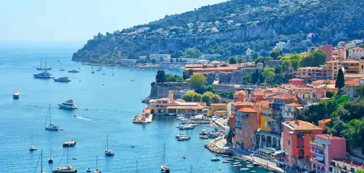 Bright picturesque view of the orange houses in Nice, overlooking the wide blue French Riviera. 