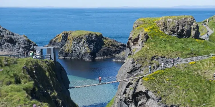 People cross the famous Carrick-A-Rede Rope Bridge in County Antrim, Northern Ireland