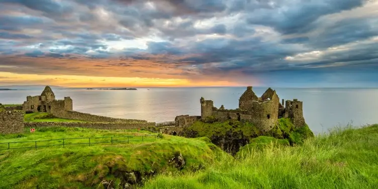 Dunluce Castle against the backdrop of the sea and sunset