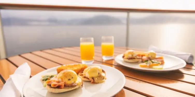 Breakfast is served on a table on the balcony of a cruise ship