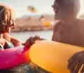 Older couple on holiday having fun in the sea with colourful inflatable rings