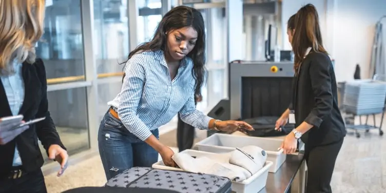 Woman collects her belongings after checks at airport security