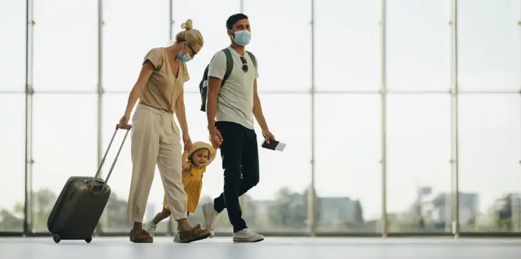 Family travelling together wearing COVID-19 masks
