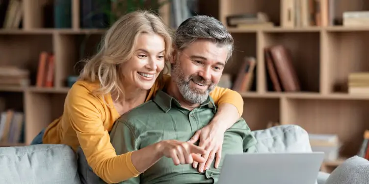 Couple planning their holiday on a laptop, to reduce any anxious feelings.