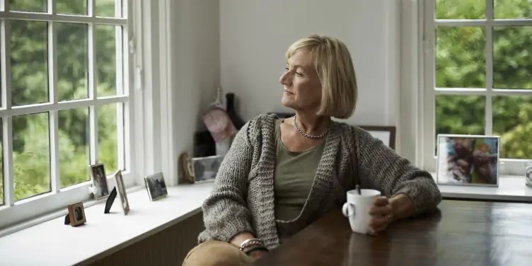 Woman relaxing by admiring nature outside her window. 