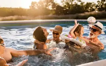 Multi-generation family playing in swimming pool