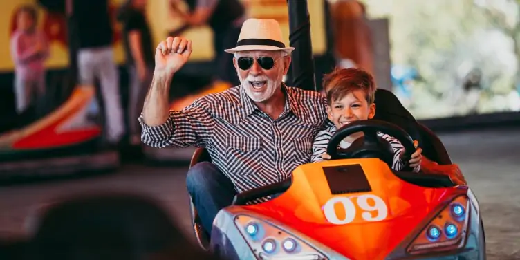 Grandfather and grandson in a bumper car on holiday