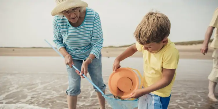 Grandmother playing with grandson on the beach