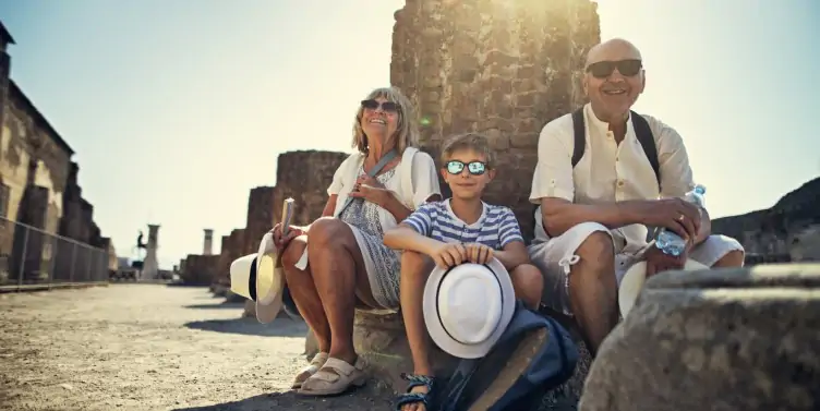 Senior couple with grandson sightseeing ancient ruins on holiday