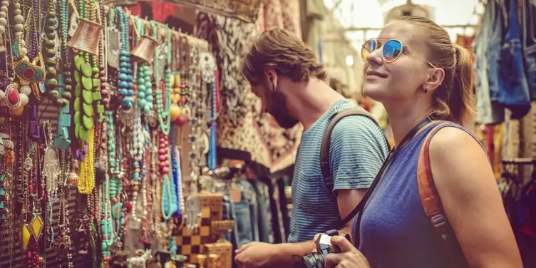 Young woman and man walking through local market in Israel