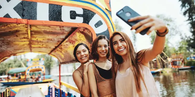 Three young girls pose for a selfie photo aboard a boat on holiday in Mexico