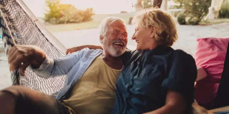 senior couple having a relaxing moment in a hammock by the sea