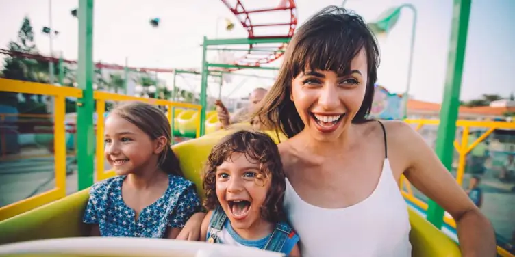 A mother and her two young daughters making memories on a rollercoaster ride