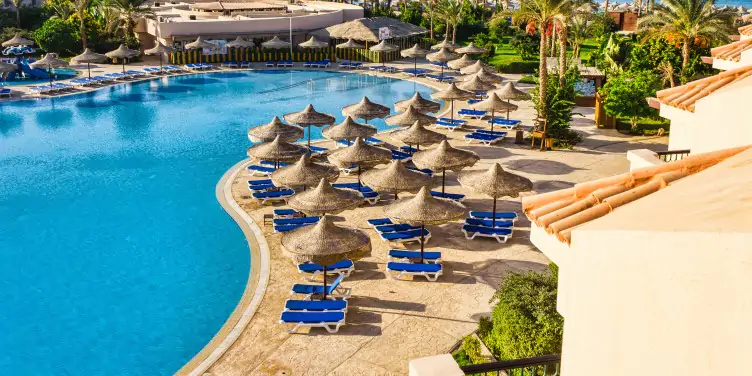 Swimming pool with sun loungers at luxury hotel tourist resort in Sharm El Sheikh, Egypt