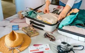 Woman packing her suitcase with all the bits she needs for a perfect summer getaway.