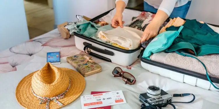 Woman packing her suitcase with all the bits she needs for a perfect summer getaway.