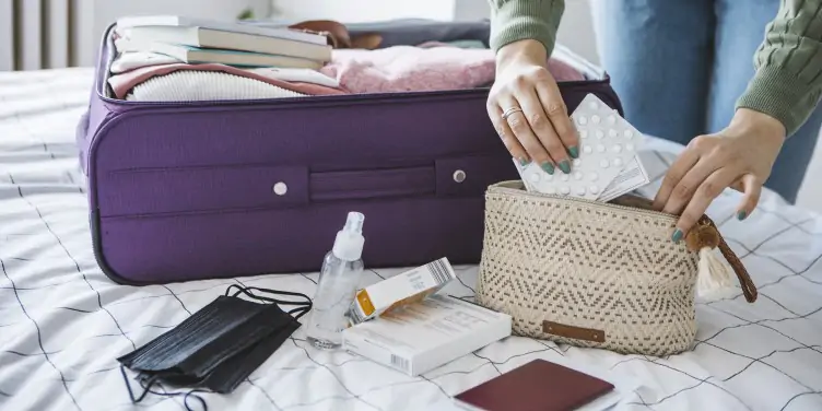 Woman packing medication in her suitcase.